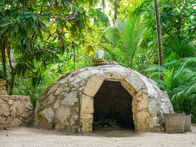 Stone dome temazcal structure in lush jungle greenery, Yucatan Mexico